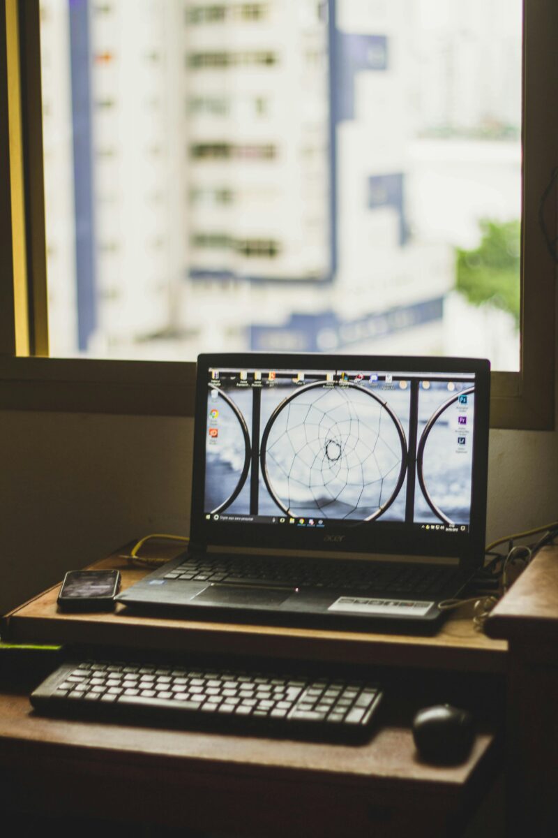 Cozy indoor workspace featuring a laptop and window view of city buildings.
